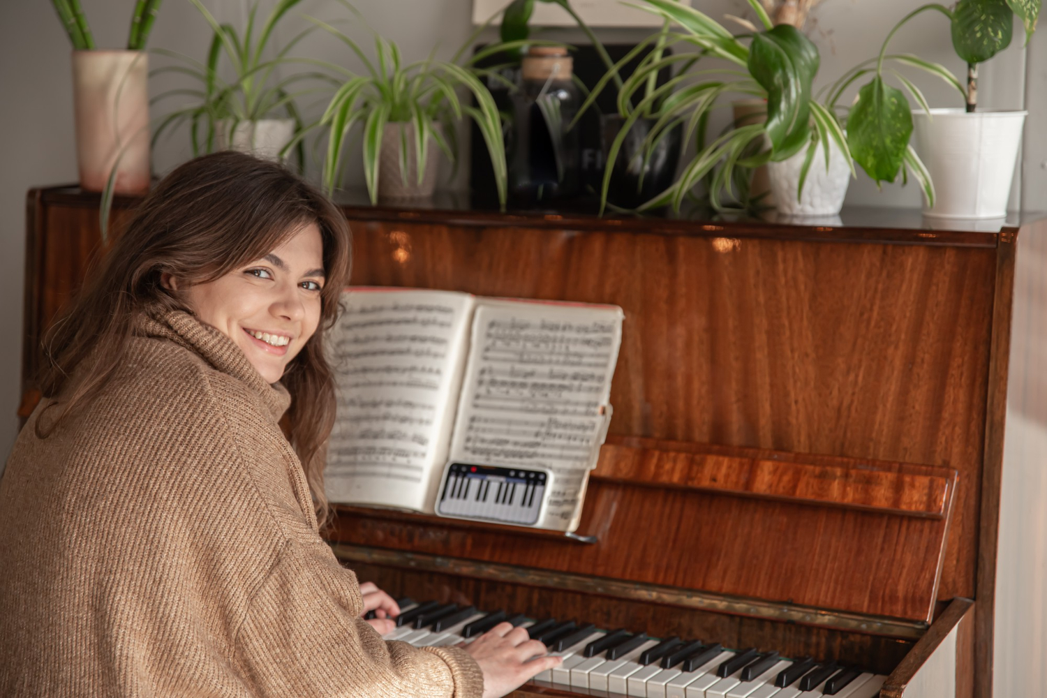 Akustik piyanoda nota çalışması yapan gülümseyen öğrenci – Piyano Akademi.